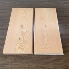 Two light wooden planks laid side by side with a narrow gap on a dark wood surface.